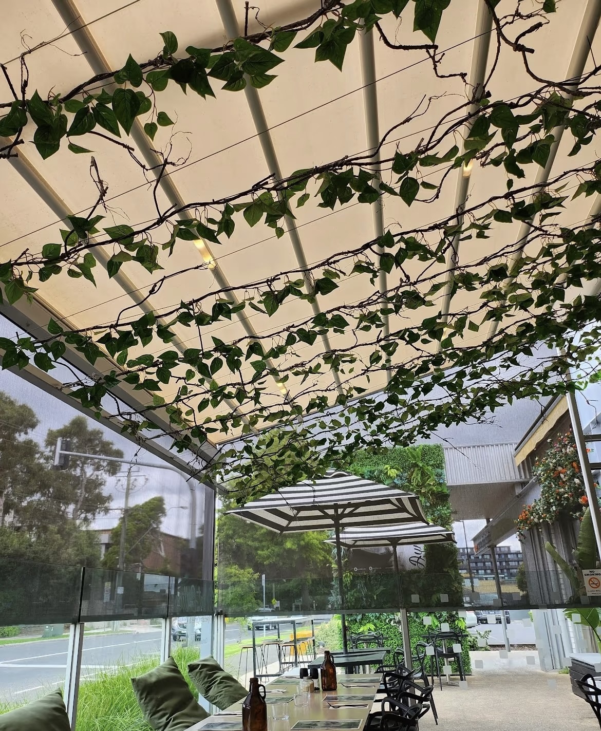 Outdoor seating area with vine-covered ceiling